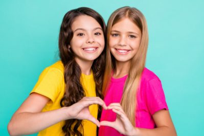 Insight Orthodontics - Young girls smiling in front of blue background